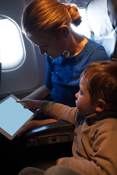 istock Mother traveling on a plane with her small son 483859627