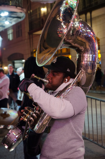 New Orleans, USA - November 23, 2013: A black man is playing a tuba outside in the streets of New Orleans (Louisiana) during a night of fall.