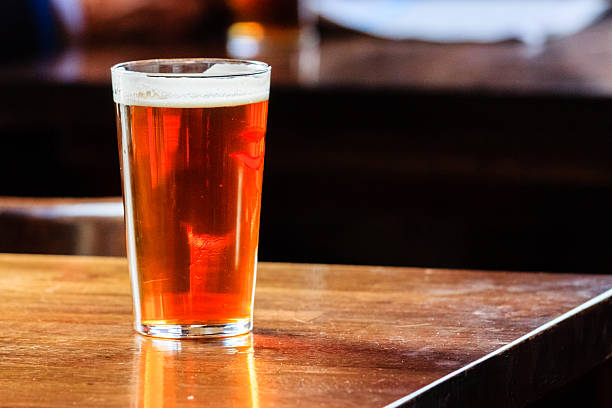 английский ale на столе - amber beer стоковые фото и изображения