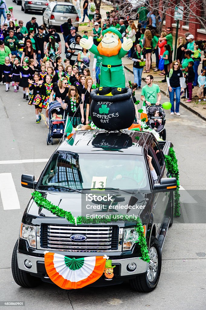 Truck used as a float in St. Patrick's day parade Little Rock, Arkansas, USA - March 15, 2014: A truck is decorated with banners and an inflatable figure of a leprechan while participating in a St. Patrick's day parade. Children from an irish dance group follow behind, and spectators watch from the side. St. Patrick's Day Stock Photo