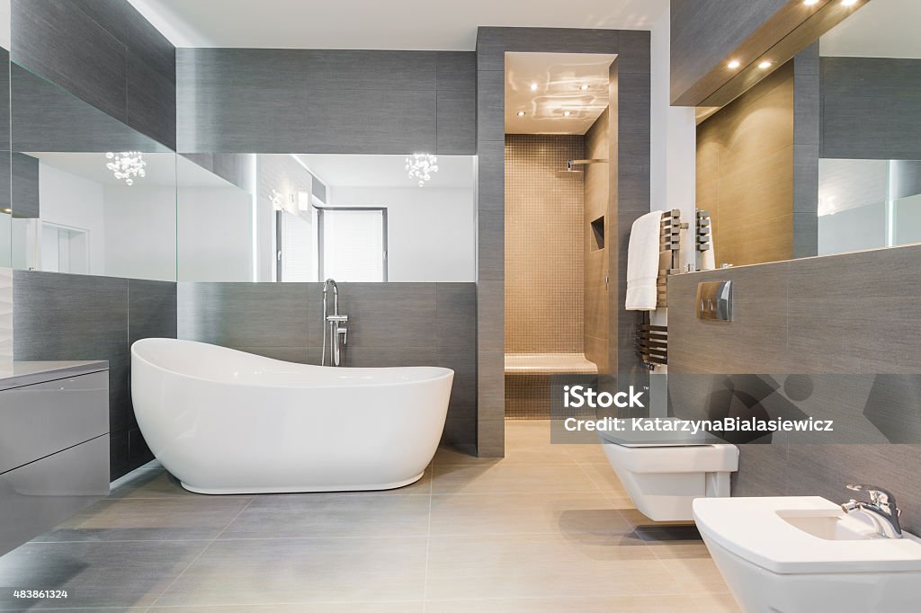 Freestanding bath in modern bathroom Designed freestanding bath in gray modern bathroom Bathroom Stock Photo