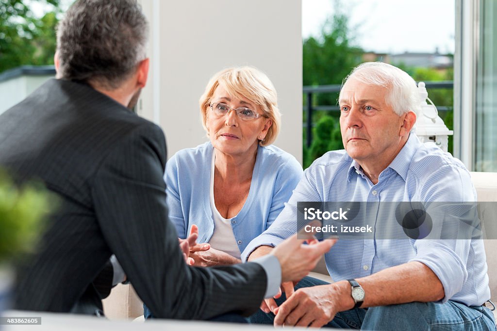 Senior couple talking with financial advisor Worried senior couple having meeting with financial advisor or insurance agent at home. Lawyer Stock Photo