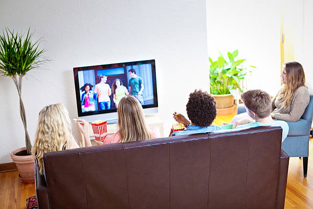 grupo de jovens amigos assistindo tv juntos em casa de filme - entertainment center watching tv television popcorn - fotografias e filmes do acervo