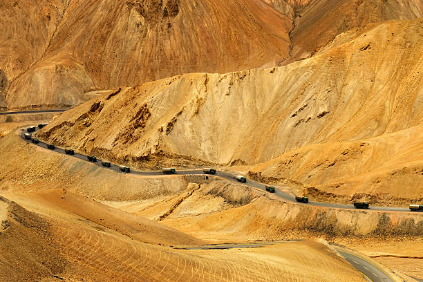 Aerial view of Zigzag road - famously known as jilabi road at old route of  Leh Srinagar Highway, trucks passing, Ladakh, Jammu and Kashmir, India