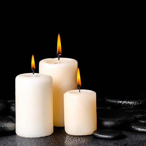 istock spa concept of white candles on zen stones with drops 483868926