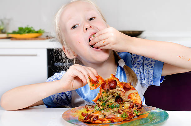istock Happy young girl eating pizza 483870422