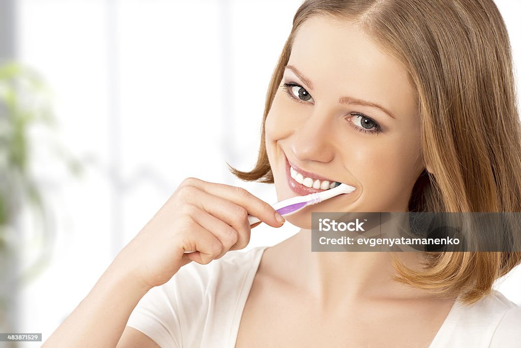 Szczęśliwa kobieta szczotkowanie zębów szczoteczką do zębów - Zbiór zdjęć royalty-free (Ciąć)