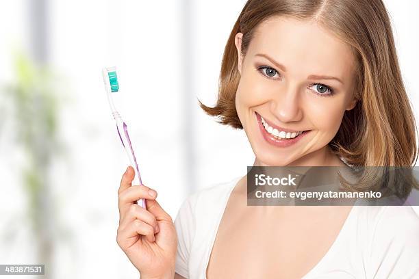 Photo libre de droit de Femme Heureuse Se Brosser Ses Dents Avec Une Brosse À Dents banque d'images et plus d'images libres de droit de Adulte