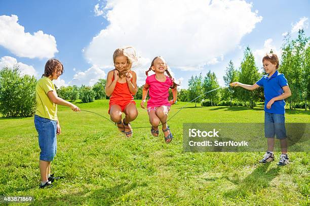 Girls Jumping Over The Rope With Friends Stock Photo - Download Image Now - Jumping Rope, Child, Skipping