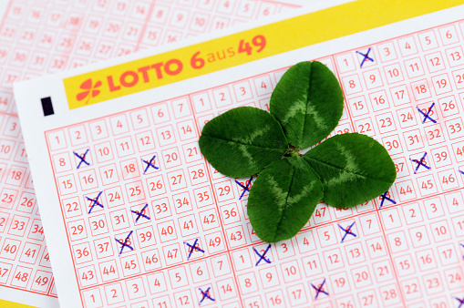 Rathenow, Germany - August 30, 2011: German Lottery Ticket for Lotto 6 aus 49 game on gray - white background. The lottery ticket is filled up with 6 crosses there game field. On right top corner appears the logo of Lottery.  On the lottery ticket laying a four leaf clover as symbol of having luck.
