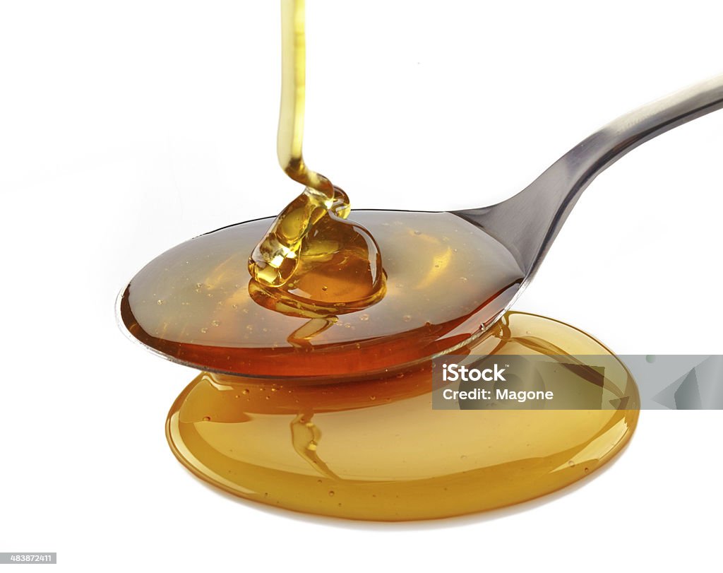 honey pouring into spoon honey pouring into spoon on a white background Cooking Stock Photo