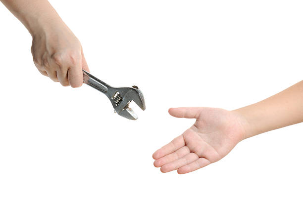 Handing over wrench stock photo