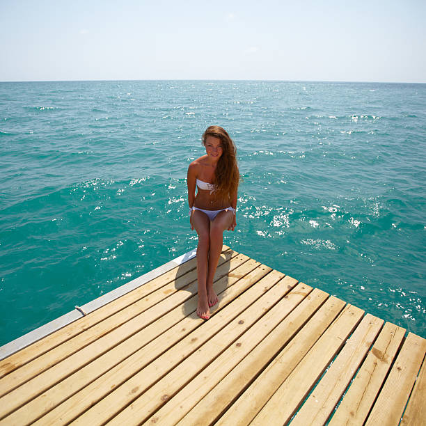 istock Young woman sitting on a beach 483873361