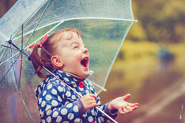 Happy in rain Little girl with umbrella in autumn raincoat photos stock pictures, royalty-free photos & images