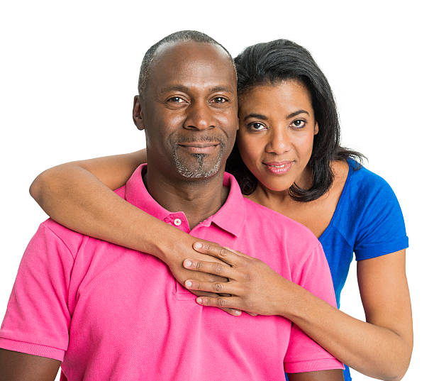 A serious studio profile portrait of a beautiful African-American couple posing for maternity portraits with a dark and moody tone.