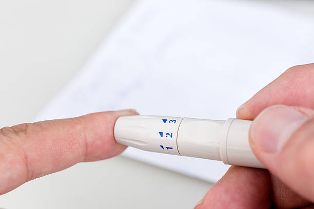 istock Man measuring blood sugar with lancing device 483874002