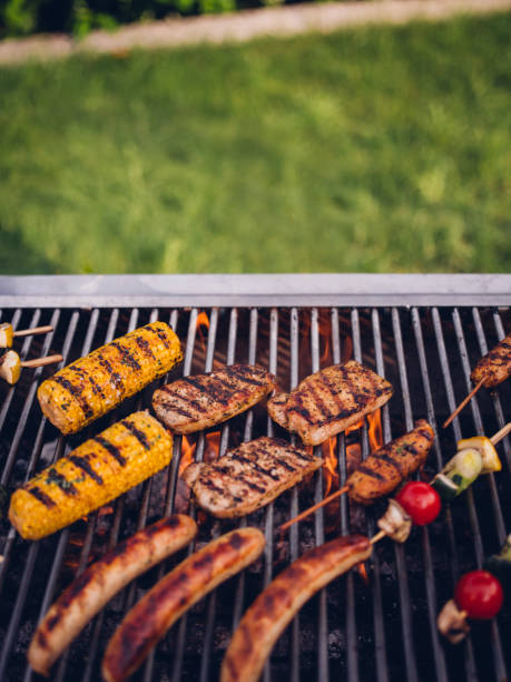 istock Barbecue in a back yard with chicken, sausages, corn grilling 483874038