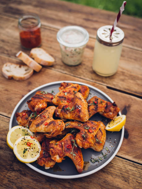 istock Spicy chicken wings with summer beverage and condiments 483874050