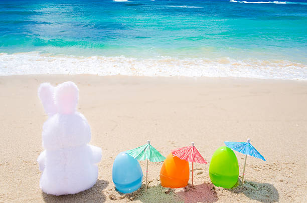 istock Easter bunny and color eggs on the beach 483874069