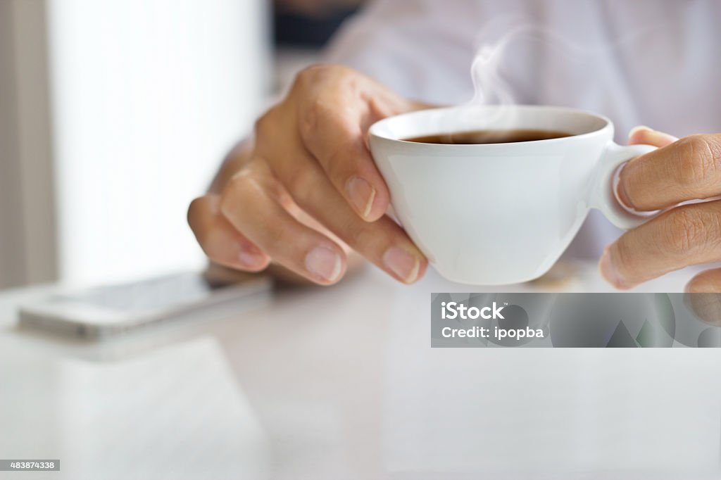 businessman and a cup of coffee in hand, blank text businessman and a cup of coffee in hand, blank text and soft focus Tea - Hot Drink Stock Photo