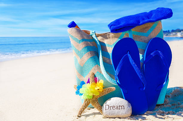istock Beach bag with flip flops by the ocean 483874499