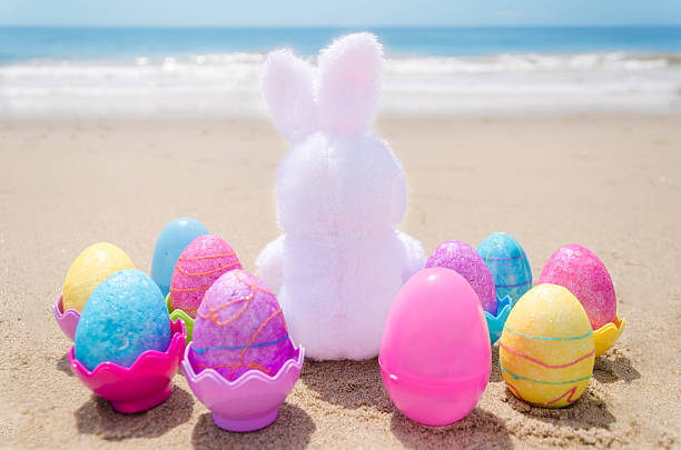 istock Easter bunny and color eggs on the beach 483874617