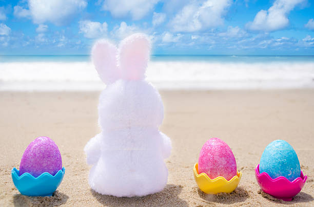 istock Easter bunny and color eggs on the beach 483874619