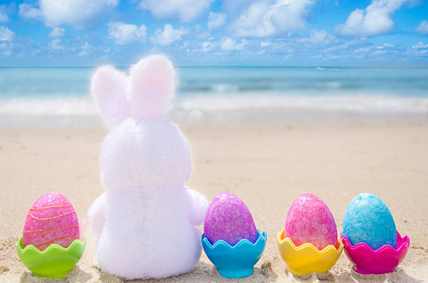 istock Easter bunny and color eggs on the beach 483874629