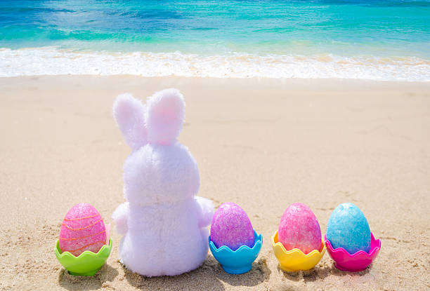istock Easter bunny and color eggs on the beach 483874631