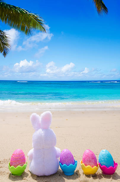 istock Easter bunny and color eggs on the beach 483874633