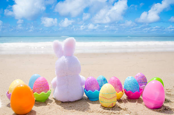 istock Easter bunny and color eggs on the beach 483874635