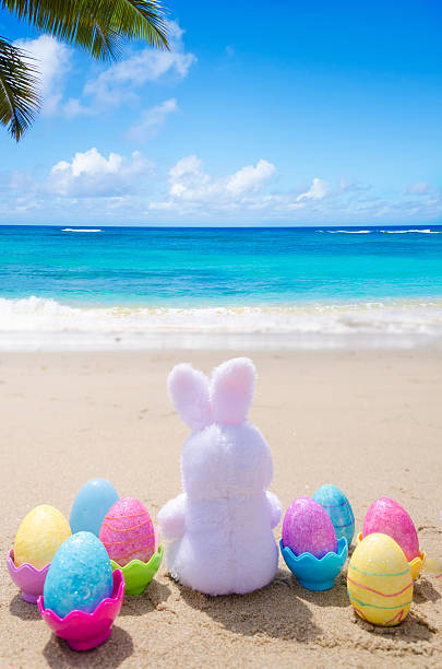 istock Easter bunny and color eggs on the beach 483874637