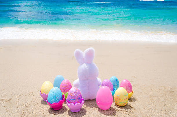 istock Easter bunny and color eggs on the beach 483874641