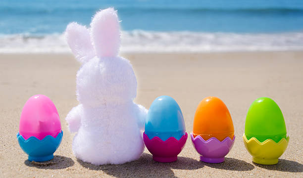 istock Easter bunny and color eggs on the beach 483874649