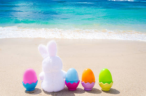 istock Easter bunny and color eggs on the beach 483874651