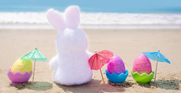 istock Easter bunny and color eggs on the beach 483874683