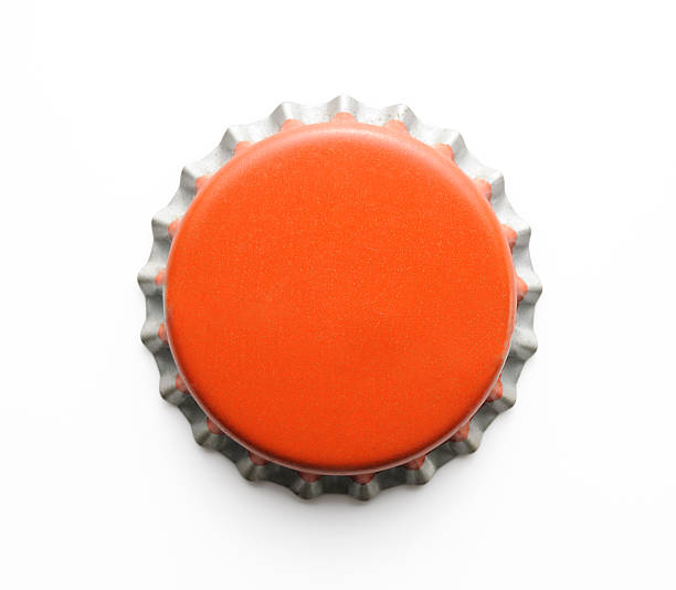 Isolated shot of old red metal bottle cap on white Old red metal bottle cap isolated on white background with clipping path. bottle cap stock pictures, royalty-free photos & images