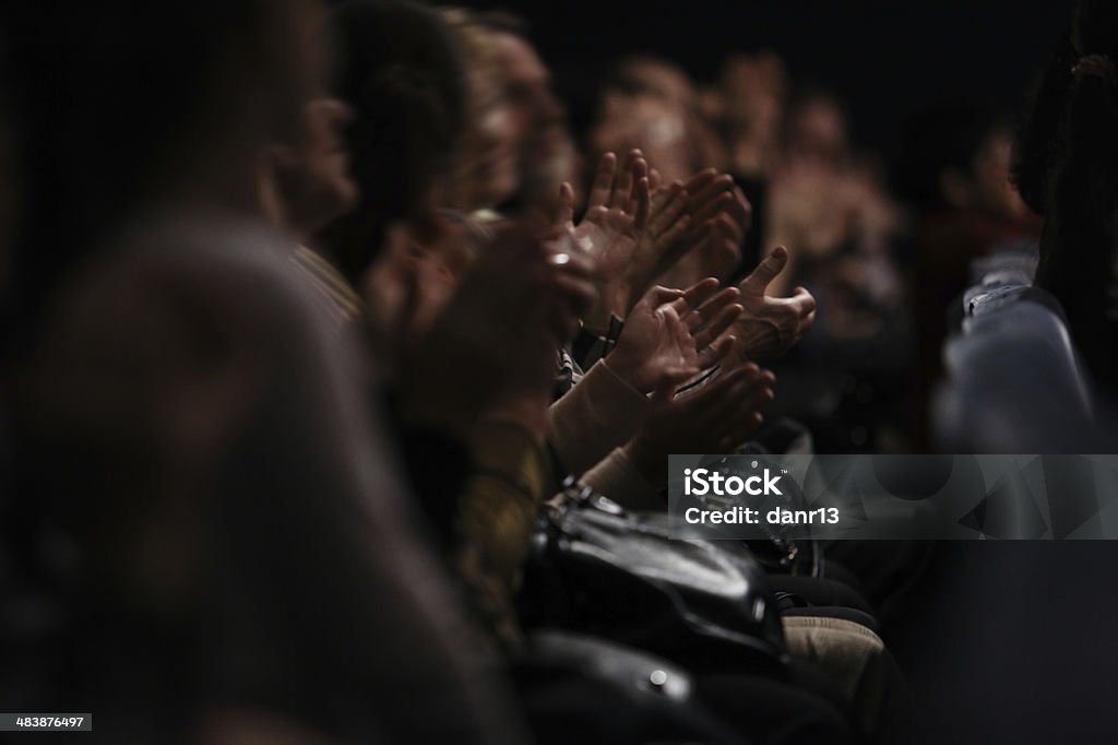 Audience clapping their hands View down a row of people sitting in an audience of people clapping their hands in appreciation of a performance Stage Theater Stock Photo