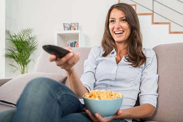 istock young woman with popcorn watching the tv 483877978