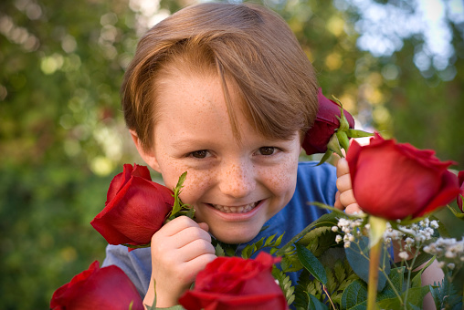 A boy presenting a bouquet of red roses to his mom. (SEE LIGHTBOXES BELOW for more in this series, as well as many more photos of this model and his sibling, Valentine's day & holiday food photos...)