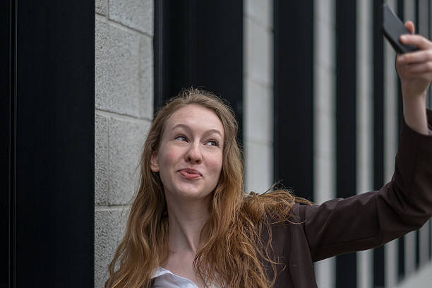 istock Playful young woman taking a selfie 483878874