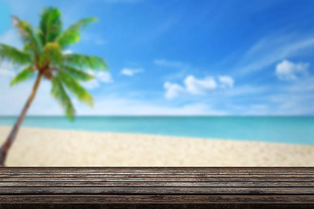 istock clean wood table beach and palm in background 483893968