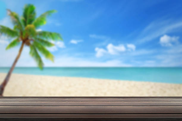istock clean wood table beach and palm in background 483894300