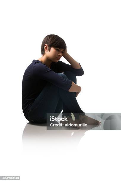 Side View Of Teenage Girl Sitting On Floor And Thinking Stock Photo - Download Image Now