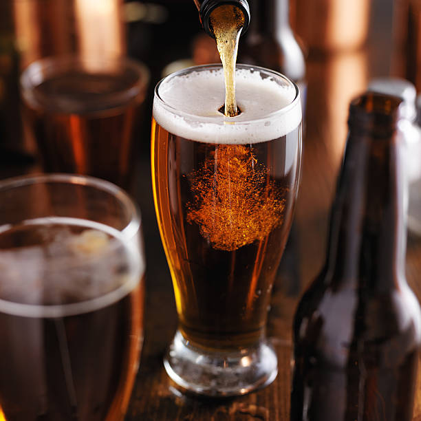 verre dark robuste de la bière - amber beer photos et images de collection