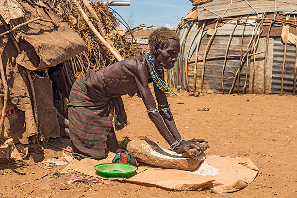 Old woman from the African tribe Dasanesh, Ethiopia Omo Valley, Ethiopia - May 6, 2015 : Old woman from the African tribe Dasanesh working hard in front of her hut. omo river photos stock pictures, royalty-free photos & images