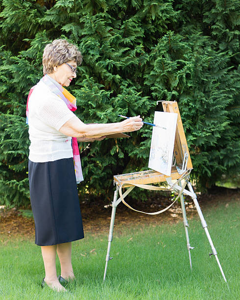 istock Old lady is drawing a picture outside 483906970