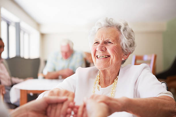Happy to help An elderly woman being helped up by a nurse in her old age home good doctor photos stock pictures, royalty-free photos & images