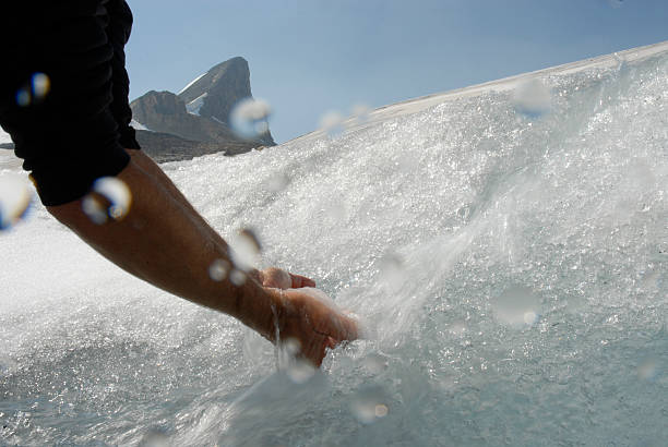 istock Person's arms scoop meltwater from glacial spring 483913490