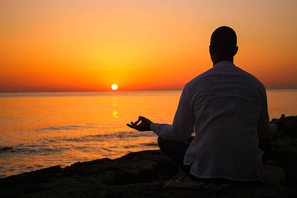 istock silhouette of a man practicing yoga at sunset 483914110